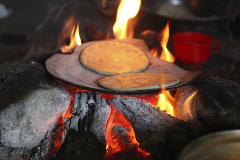 two tortillas cooking on cookfire