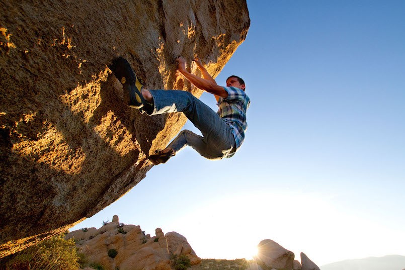 man in plaid shirt bouldering climbing