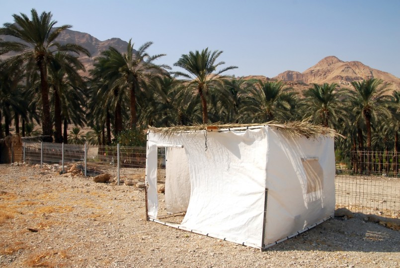 A sukkah in the desert. A sukkah is a temporary hut constructed for use during the week-long Jewish festival of Sukkot. It is topped with branches and often the interior is decorated