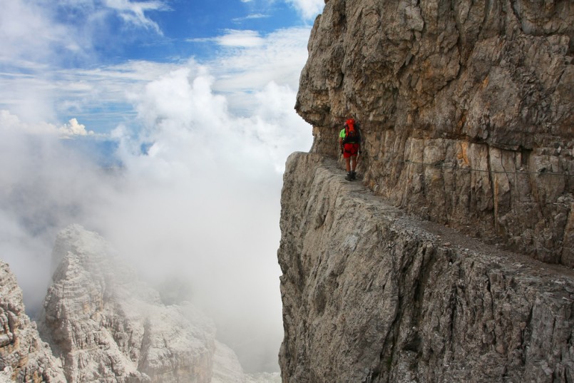A man going through the difficult part of ferrata - Dolomiti mountains, Dolomiti di Brenta, Italy