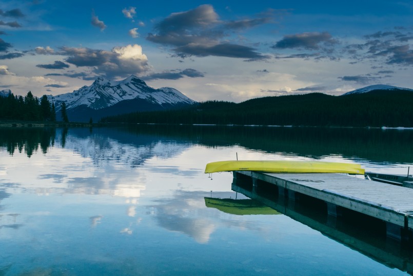 bright kayak on dock over lake with mountains