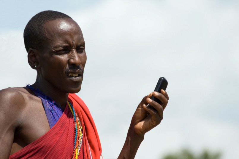 Native Masai with Cellphone in Masai Mara National Park, Kenya