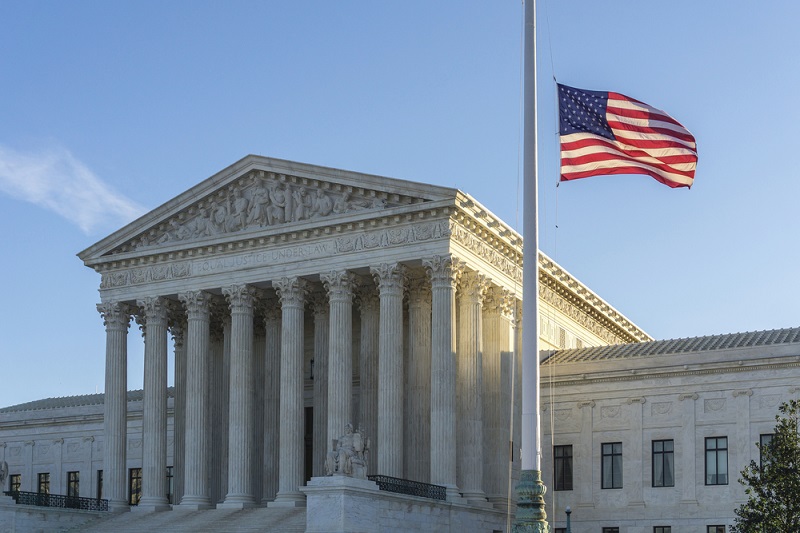 WASHINGTON, DC, USA - FEBRUARY 14, 2016: Flags fly at half-staff at the United States Supreme Court as the sun rises on the first day after Justice Antonin Scalia's death was announced.