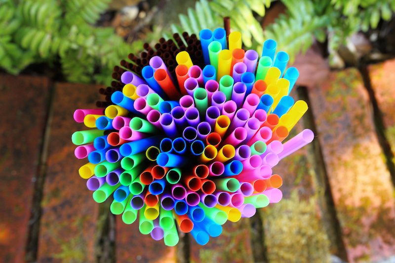 colored drinking straws with nature background - close up