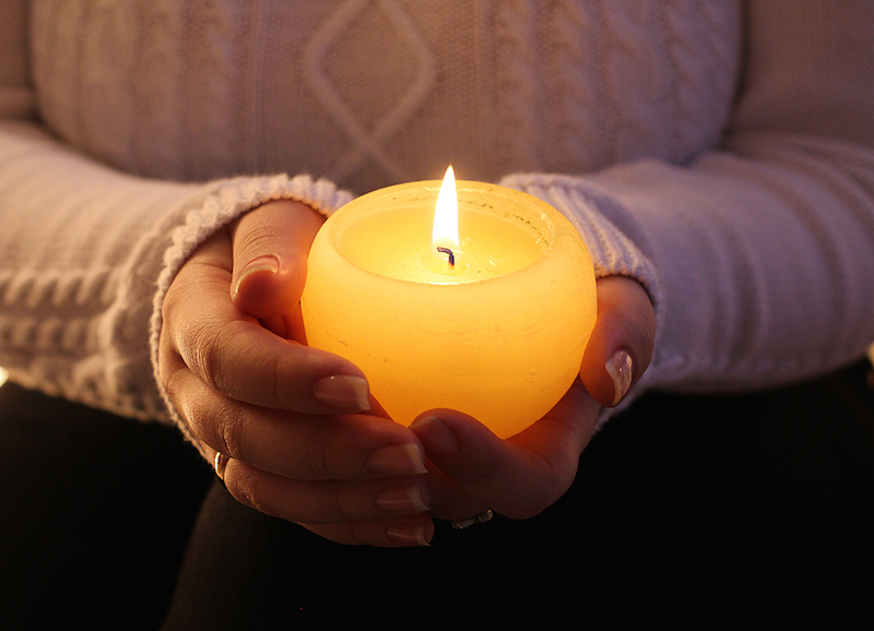 burning candle in the hands of a girl christmas candles